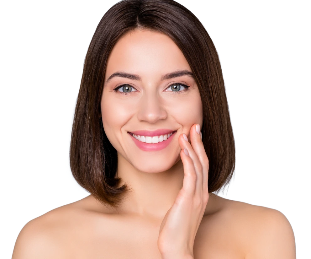 Woman with dark hair and pink lipstick smiling while touching her cheek against white background