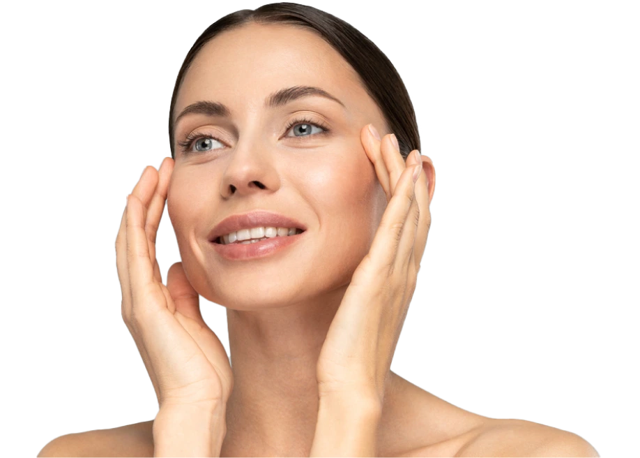 Woman with glowing skin smiling while touching her face with both hands against white background